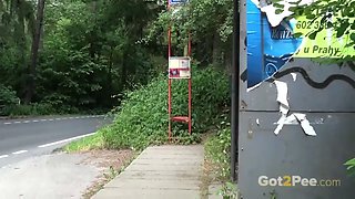 Pretty brunette is nearly caught pissing in a bus stop!