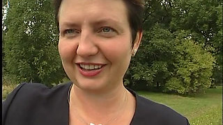 Lovely mature lady blows a guy's cock outdoors near the car