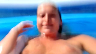 Milf seductress fingering her shaved pussy in the pool