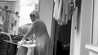 Naked chubby woman hangs out laundry on the balcony for