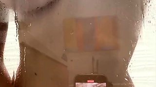 Busty vixen poses naked and plays with herself in the shower